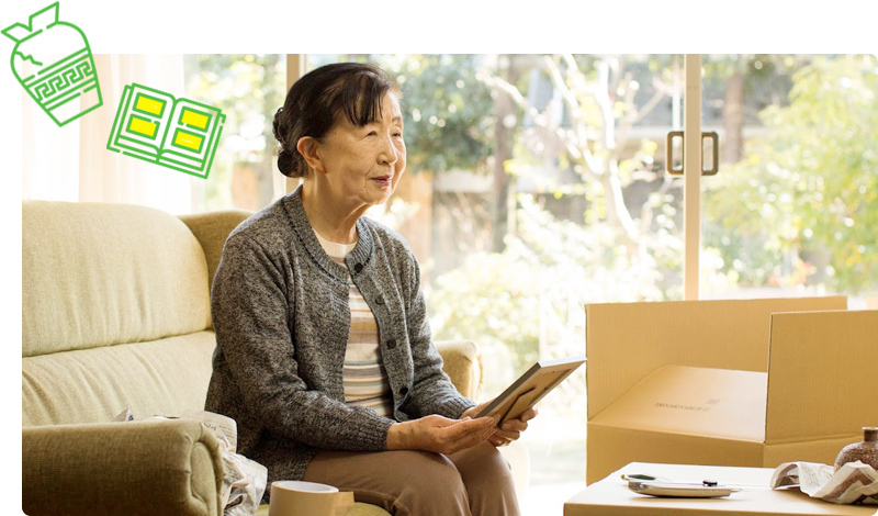ソファに座り本を手に取る女性